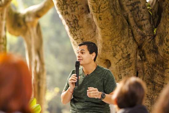 Jonas Masetti ministrando aulas e conselhos ao ar livre próximo de uma árvore.
